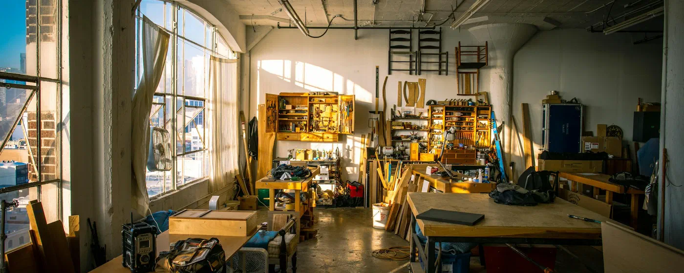 Atelier baigné de lumière dorée, établis et outils en bois